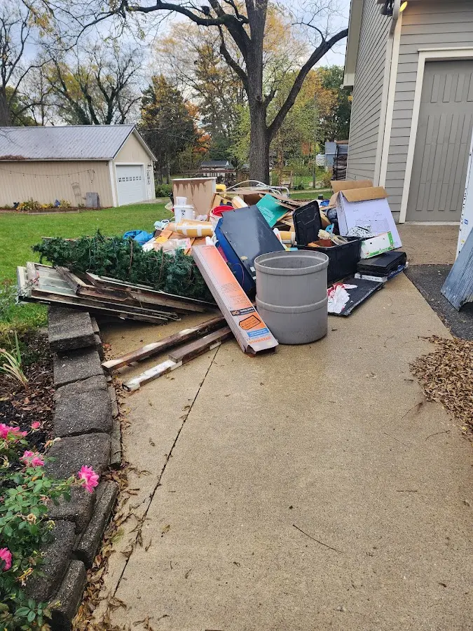 Dumpster being loaded with debris for Roofing Dumpster Rental in Highland Park